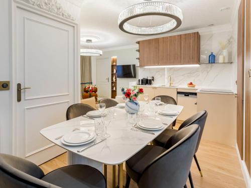 une salle à manger avec une table et des chaises blanches dans l'établissement Merveil - Luxury Suite - Marais - Lenoir I, à Paris