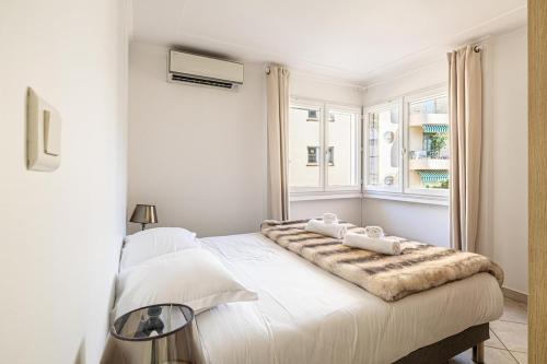 - une chambre blanche avec un grand lit et 2 oreillers dans l'établissement 78 LERINS - Bel appartement 2 chambres sur la Croisette, à Cannes