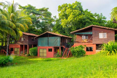 a group of houses in a grassy field at Las Cabañas Encantadas de Nindirí in Nindirí