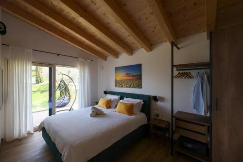 ein Schlafzimmer mit großem Bett und Fenster in der Unterkunft Podere Sabaina, Private Villa mit Pool, Seeblick und 3 Wohneinheiten zur Alleinnutzung in Torri del Benaco