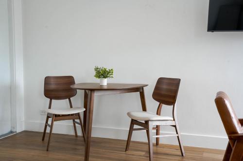 a table with three chairs and a table with a plant on it at The Jaxon in West Palm Beach