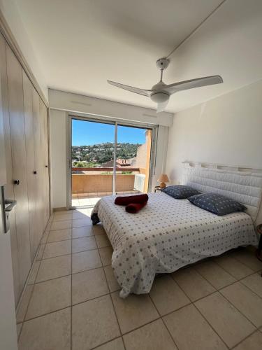 une chambre avec un lit et une grande fenêtre dans l'établissement Sea View Apartment, St Clair, au Lavandou