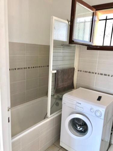 une salle de bain avec une machine à laver et un lave-linge dans l'établissement Sea View Apartment, St Clair, au Lavandou