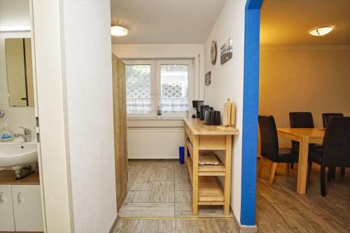Cette chambre comprend un bureau, un lavabo et une table. dans l'établissement FeWo am Hochzeitsberg FeWo 17 - Souterrain, à Breege