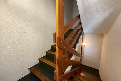 a wooden staircase in a room with a white wall at Beautiful detached house facing the slopes in Valberg