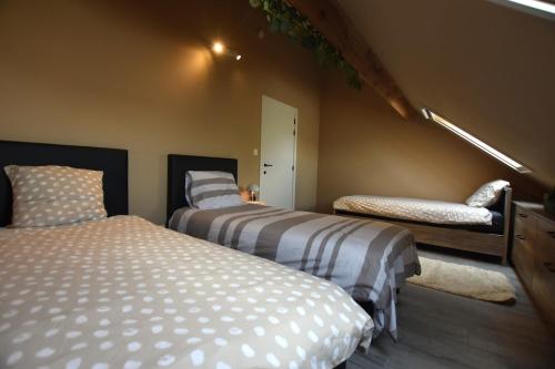 a bedroom with two beds and a bench in it at Gezellig en comfortabele studio vlakbij Gent in Evergem
