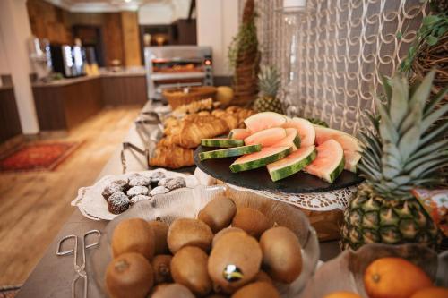 a table topped with plates of fruit and other foods at Wohlfühlhotel Innertalerhof in Gerlos