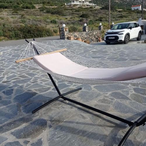 a hammock on top of a parking lot with a car at Tholos Alexandra's Beachfront House in Kavoúsion