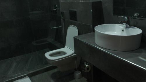 a bathroom with a white toilet and a sink at Columbus hotel in Eldoret