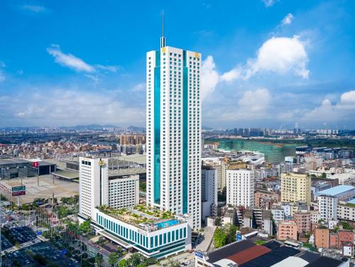 a tall white building in a large city at Regal Palace Hotel in Dongguan