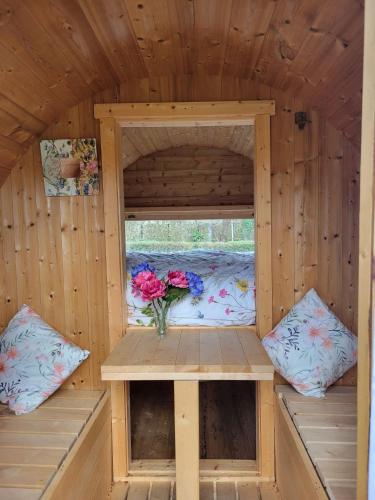 a wooden cabin with a window and a vase of flowers at Cozy Wooden Chalet in Abilly, France in Abilly-Sur-Claise