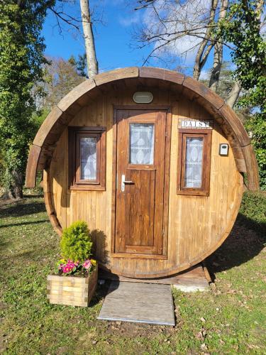 a small wooden hobbit house with a door and flowers at Cozy Wooden Chalet in Abilly, France in Abilly-Sur-Claise