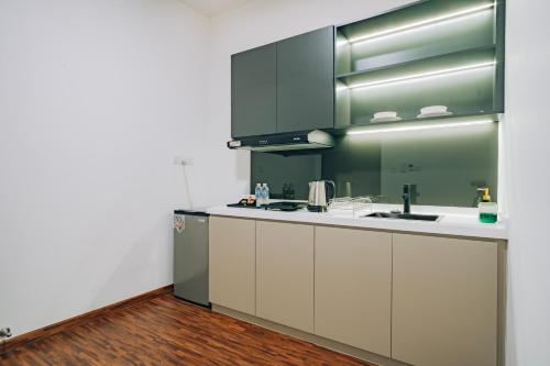 a kitchen with white cabinets and a sink at K AVENUE TOWER B by The Pillow House, 5 Minutes to KKIA Airport in Penampang