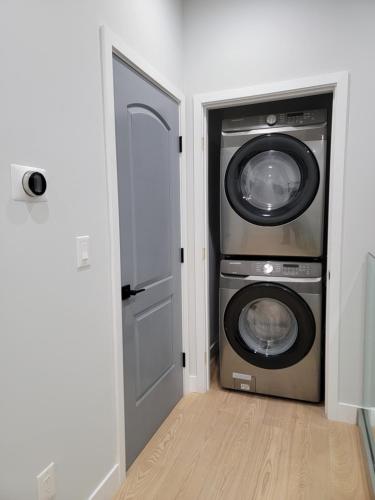 a laundry room with a washer and dryer at Newly constructed 2 bedroom by La Cienega Plaza with parking, modern kitchen, washer dryer and very central to attractions in Los Angeles