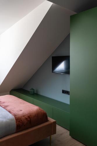 a bedroom with a bed with a green wall at Core - Corporate Studios by Weeklyflex in Strassen