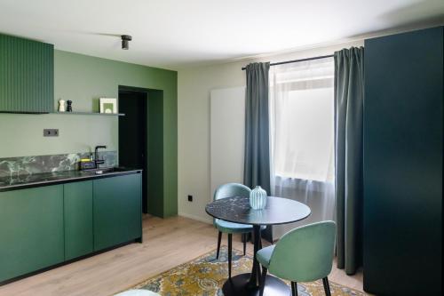 a kitchen with green cabinets and a table and chairs at Core - Corporate Studios by Weeklyflex in Strassen