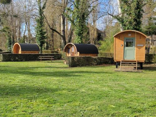 quelques petites huttes dans un champ d'herbe dans l'établissement Small cosy Bluebell cabin in the French countryside, à Abilly-Sur-Claise