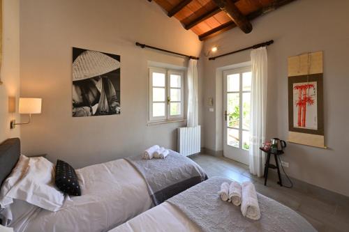 a bedroom with two beds with towels on them at La Grande Via, ospitalità in Maremma in Montemerano