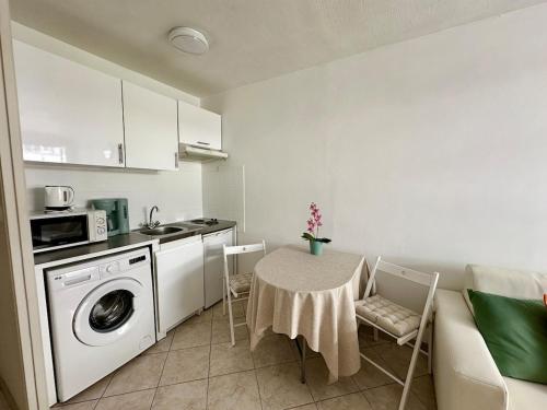 une cuisine avec une table et une machine à laver dans l'établissement Studio Riviera - balcon et Wifi, à Nice