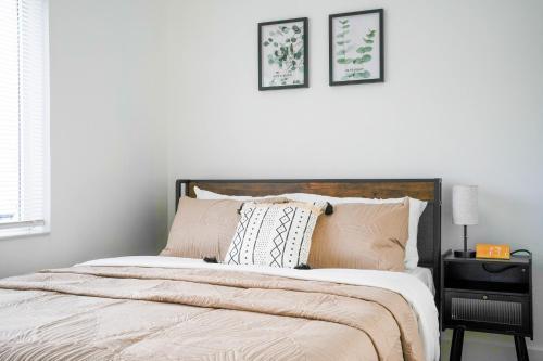 a bedroom with a bed with two pictures on the wall at The Jaxon in West Palm Beach