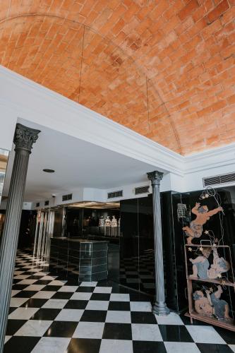 a lobby with a black and white checkered floor at Hotel Gran Derby Suites, a Small Luxury Hotel of the World in Barcelona