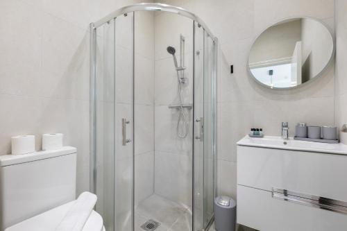 a bathroom with a shower and a toilet and a mirror at London 5 BR 3 Bathroom Garden Hse Near Metro and Hampstead Heath Sleeps 10 in London