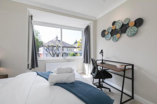a bedroom with a bed and a desk and a window at London 5 BR 3 Bathroom Garden Hse Near Metro and Hampstead Heath Sleeps 10 in London