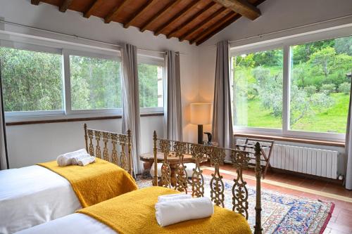a bedroom with two beds and two windows at La Grande Via, ospitalità in Maremma in Montemerano