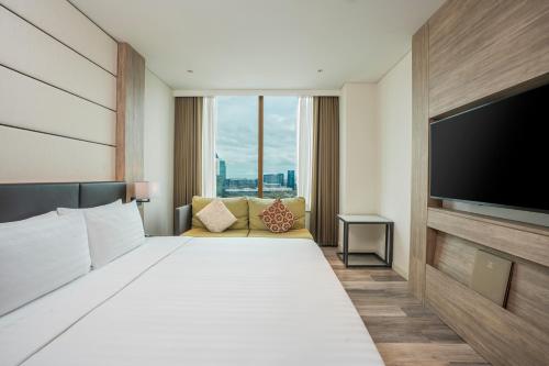 a hotel room with a large bed and a flat screen tv at Solaria Nishitetsu Hotel Bangkok in Bangkok