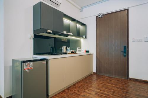 a kitchen with green cabinets and a refrigerator at K AVENUE TOWER B by The Pillow House, 5 Minutes to KKIA Airport in Penampang