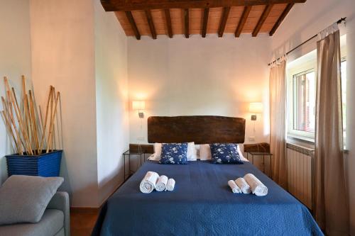 a bedroom with a bed with slippers on it at La Grande Via, ospitalità in Maremma in Montemerano