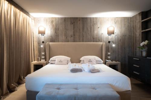 a bedroom with a large white bed with towels on it at Hotel Spinale in Madonna di Campiglio