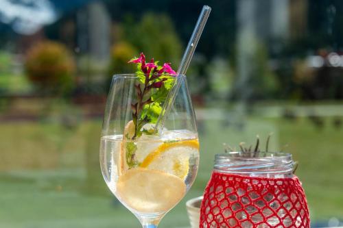 a glass of wine and a flower in a jar at Wohlfühlhotel Innertalerhof in Gerlos