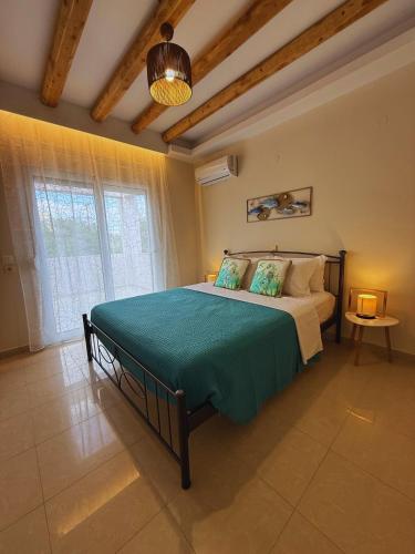 a bedroom with a large bed with a green blanket at Azure Dreams Villa with pool - Haraki beach in Haraki