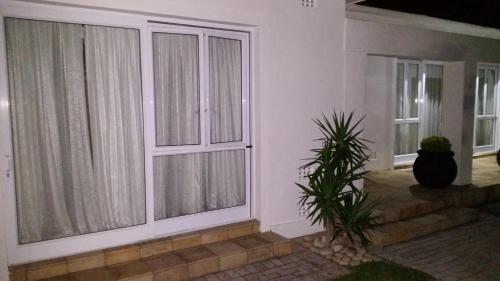 a room with two large sliding glass doors at Ballina Ga-el Guesthouse in Port Elizabeth