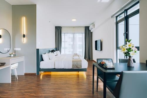 a bedroom with a bed and a desk with a desk at K AVENUE TOWER B by The Pillow House, 5 Minutes to KKIA Airport in Penampang
