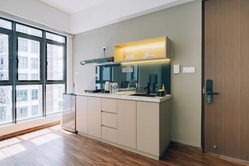 a kitchen with white cabinets and a sink at K AVENUE TOWER B by The Pillow House, 5 Minutes to KKIA Airport in Penampang