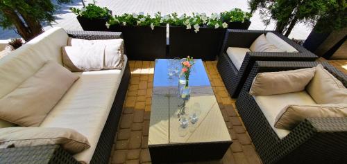 a patio with two couches and a glass table at Euphoria Residence in Sosnowiec