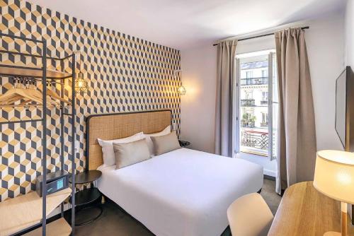 a hotel room with a white bed and a window at Best Western Aramis Saint Germain in Paris