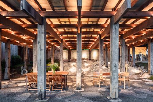 a wooden pavilion with a table and chairs at Vows Villa Beachfront in Ban Bang Po
