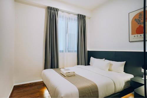 a bedroom with a large white bed with a window at K AVENUE TOWER B by The Pillow House, 5 Minutes to KKIA Airport in Penampang