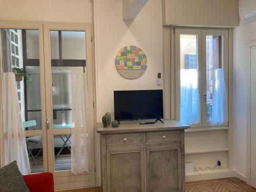 a living room with a television on a wooden cabinet at Aro's House in Cremona
