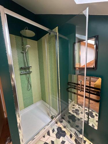 une douche avec une porte vitrée dans une salle de bain dans l'établissement LOFT DES SABLES - Loft moderne à 50m de la plage, à Plouguerneau