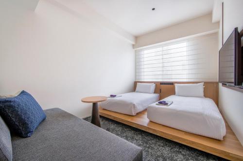 a room with two beds and a couch at Park Hotel Kyoto in Kyoto