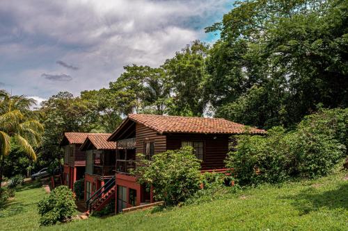 a small wooden house in a field with trees at Las Cabañas Encantadas de Nindirí in Nindirí