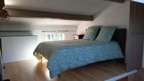 une chambre avec un lit avec une couette bleue et une fenêtre dans l'établissement Villa club, à Sanary-sur-Mer