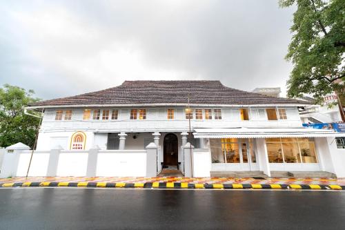 a white house with a black roof at FeelHome in Cochin