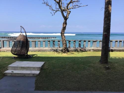 a basket hanging from a tree next to the ocean at Bali Palms Resort-412 in Candidasa