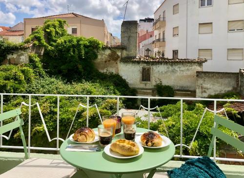 a table with two plates of pastries on a balcony at Design no centro histórico a 30 min Lisboa in Torres Vedras