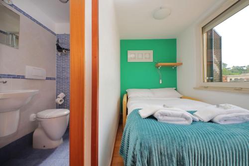 a bathroom with a bed and a toilet and a sink at Magic Trastevere suite on roof terrace in Rome